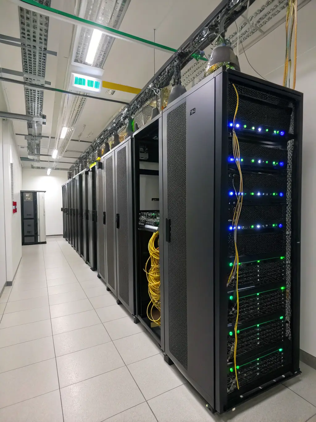 A server rack with glowing lights and a technician checking a dashboard, symbolizing reliable hosting and ongoing website maintenance for business owners.